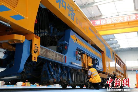 圖為工人正在清理大型養(yǎng)路機(jī)械?！堖h(yuǎn) 攝